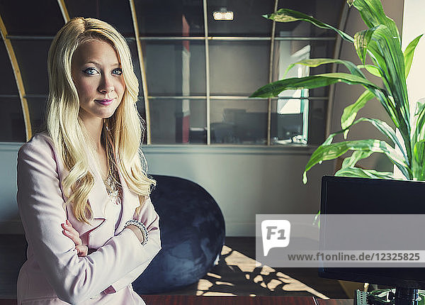 Business-Porträt einer schönen jungen Geschäftsfrau mit langen blonden Haaren und verschränkten Armen am Arbeitsplatz; Sherwood Park  Alberta  Kanada