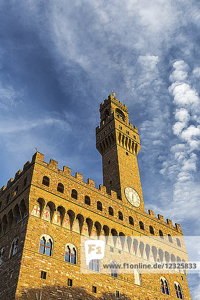 Altes Steinschloss und Turm mit dramatischen Wolken und blauem Himmel leuchtende Orange bei Sonnenuntergang; Florenz  Toskana  Italien
