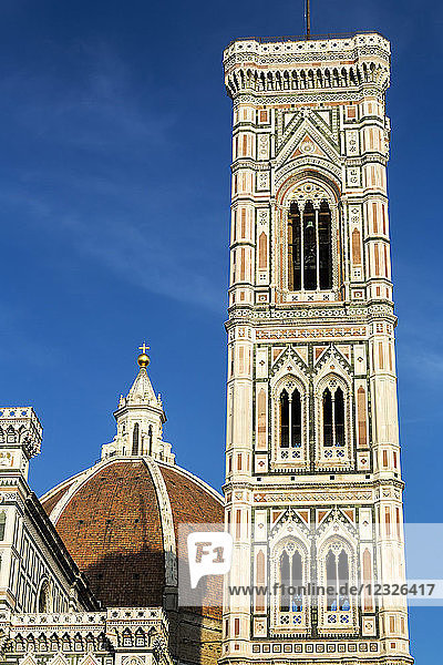 Glockenturm der Kathedrale von Florenz warm beleuchtet bei Sonnenuntergang mit blauem Himmel; Florenz  Toskana  Italien