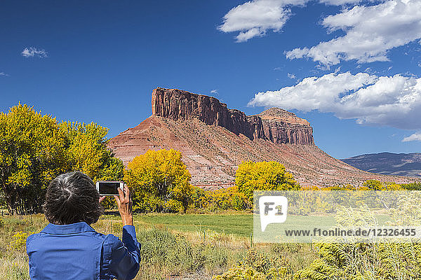 Eine Frau macht ein Handyfoto von der Felsformation 'the Palisade'; Gateway  Colorado  Vereinigte Staaten von Amerika