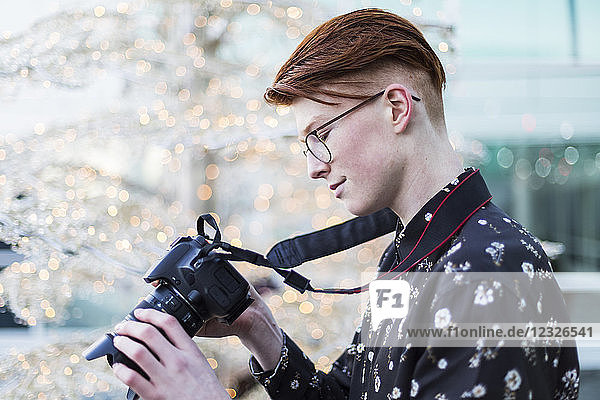 Jugendlicher  der sich die digitalen Fotos auf dem Bildschirm seiner Kamera ansieht; Vancouver  British Columbia  Kanada