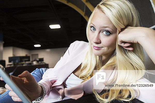 Schöne junge Geschäftsfrau mit langen blonden Haaren posiert für die Kamera am Arbeitsplatz; Sherwood Park  Alberta  Kanada