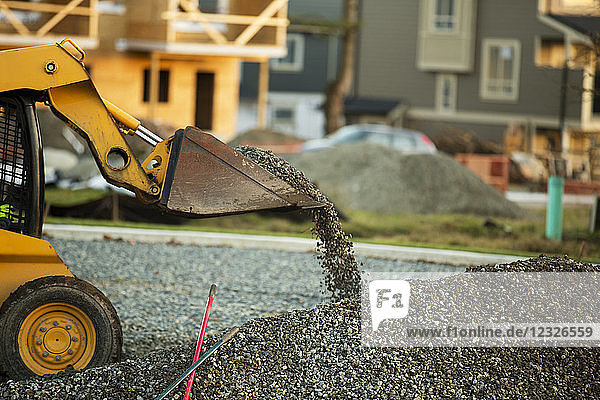Kleiner Frontlader beim Bewegen und Einbringen von Kies in einem Parkgebiet für den Bau neuer Häuser; Langley  British Columbia  Kanada