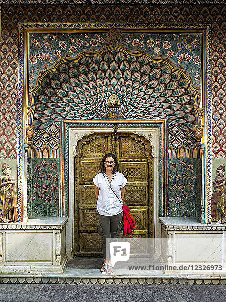 Eine Touristin steht vor dem Pfauentor  Stadtpalast; Jaipur  Rajasthan  Indien