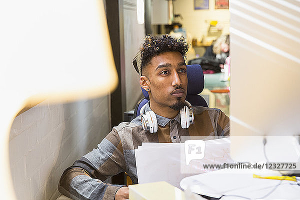 Focused creative businessman working at computer in office