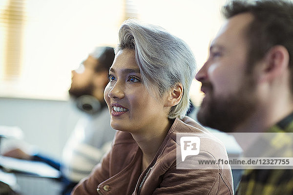 Smiling creative businesswoman listening in meeting