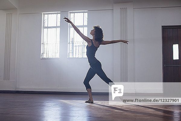 Anmutige junge Tänzerin beim Üben im Tanzstudio