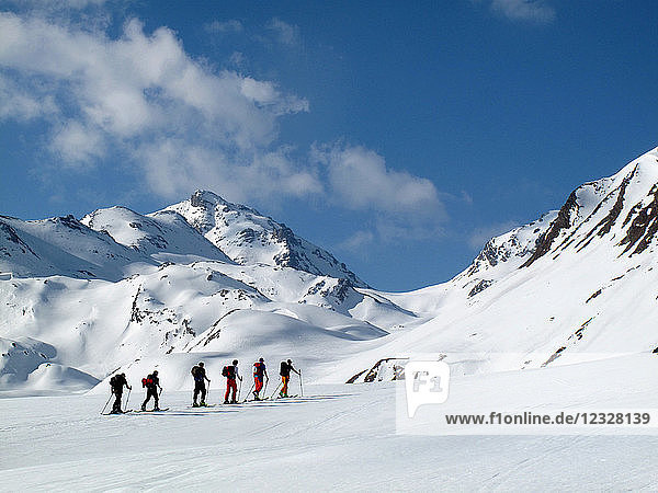 ÖSTERREICH  Tirol  Silvrettagebirge  eine Gruppe von 6 Langläufern in Indianerfeile wandert in Richtung Larainfernerspitze