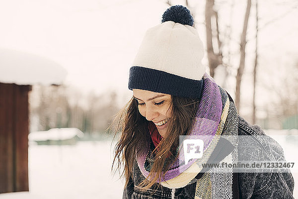 Smiling mid adult woman looking away at snow covered park