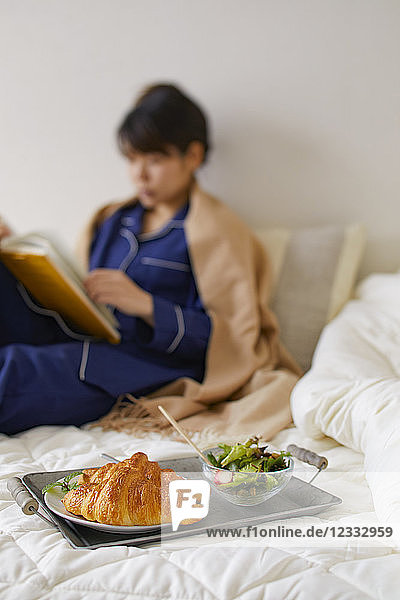 Japanese woman having breakfast in bed