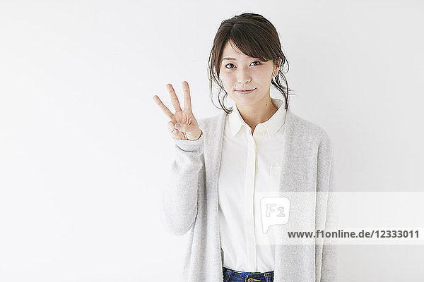 Young Japanese woman against white wall