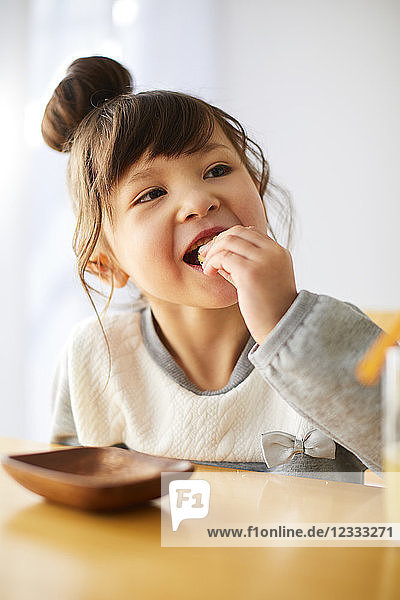 Niedliches japanisches Kind bei einem Snack