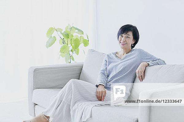 Japanische Seniorin auf Sofa