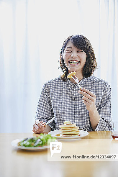 Young Japanese woman eating pancakes