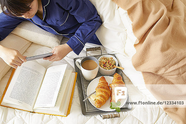 Japanese woman having breakfast in bed