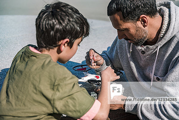 Father and son repairing drone