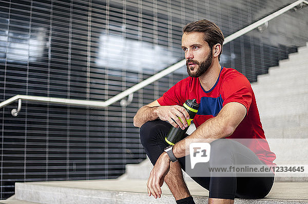 Man sitting on stairs having a break from running