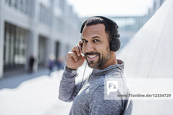 Portrait of smiling man having a break from exercising wearing headphones