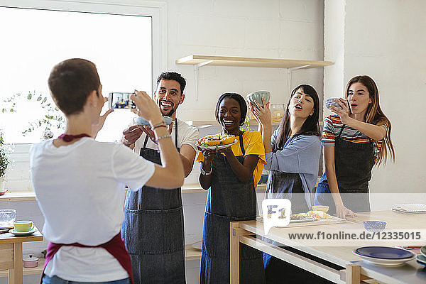 Instructor taking a picture of friends in a cooking workshop