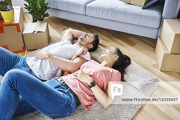 Happy couple relaxing while moving into new apartment