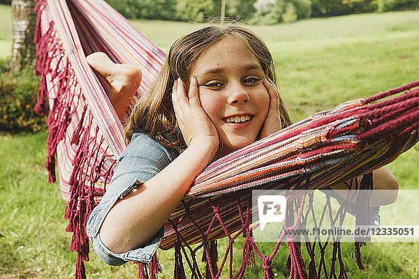 Portrait of smiling girl relaxing in hammock