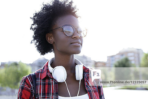 Portrait of young woman with headphones at backlight
