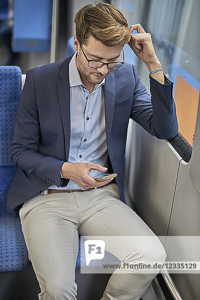 Businessman using smartphone in metro