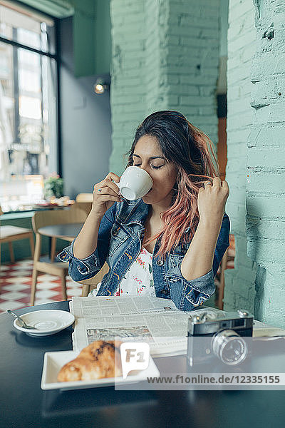 Woman sitting in coffee shop drinking coffee