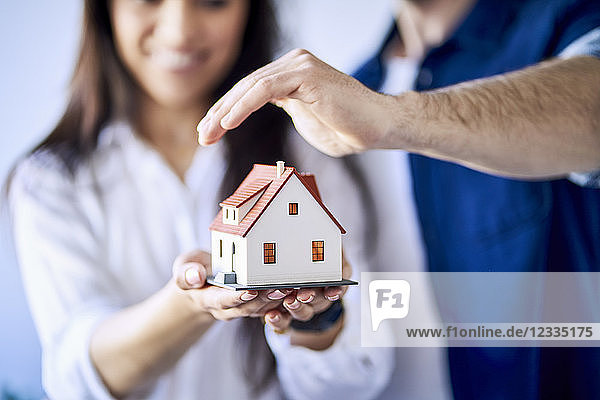 Close-up of couple holding model of new home
