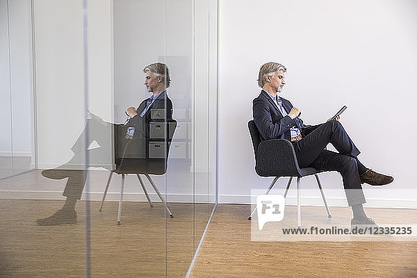 Businessman sitting on chair  using digital tablet