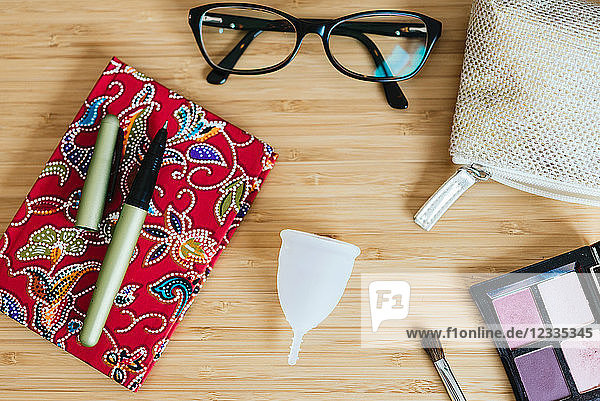 Menstrual cup on a table and notebook  pen and glasses