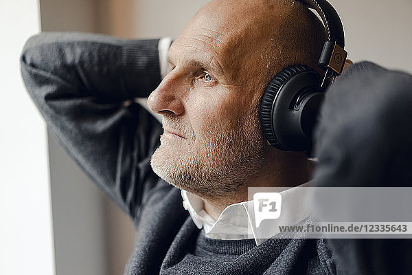 Senior man wearing headphones  listening music  portrait