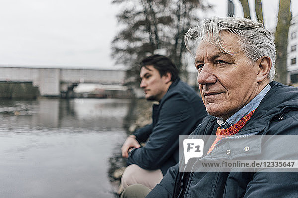 Senior man and young man at the riverside
