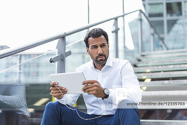 Businessman using tablet  earphone
