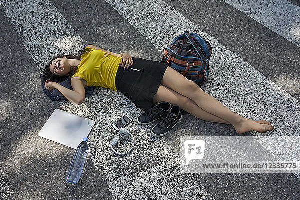 Young woman lying on zebra crossing taking a break