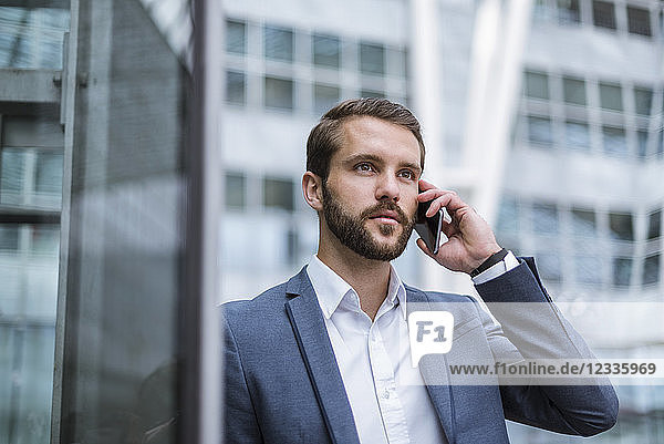 Young businessman on cell phone looking sideways
