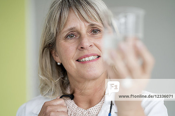 Smiling mature woman holding glass of water