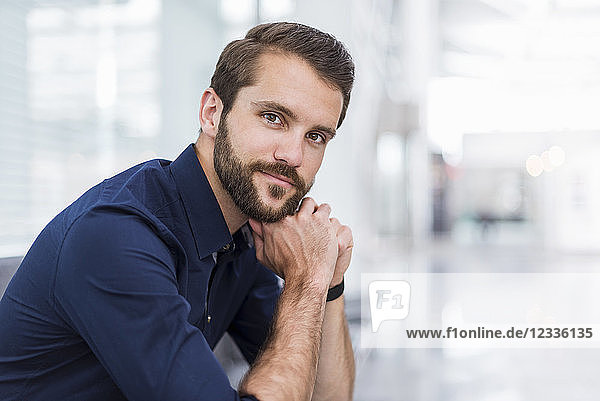 Portrait of confident young businessman sitting in waiting area