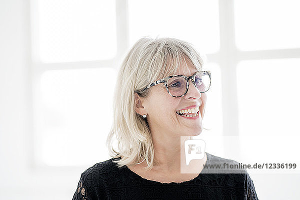 Laughing mature woman wearing glasses looking sideways