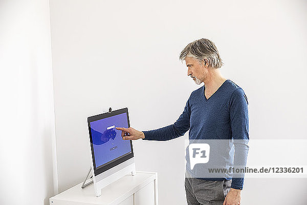 Businessman entering PIN code on touch screen