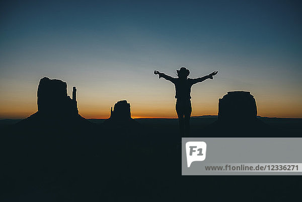 USA, Utah, Woman enjoying sunrise in Monument Valley