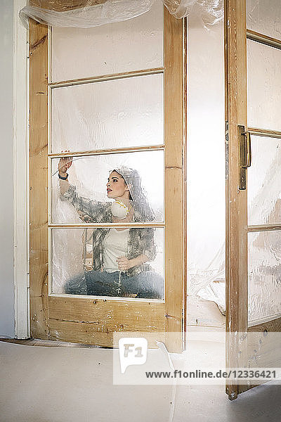 Young woman renovating her new flat  examining door