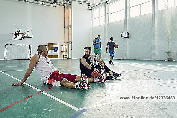 Basketball players during break  sitting on court