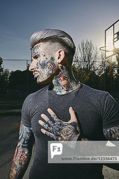 Portrait of tattooed young man on basketball court