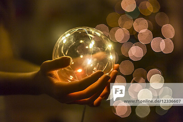 Hands of girl holding shining crystal ball