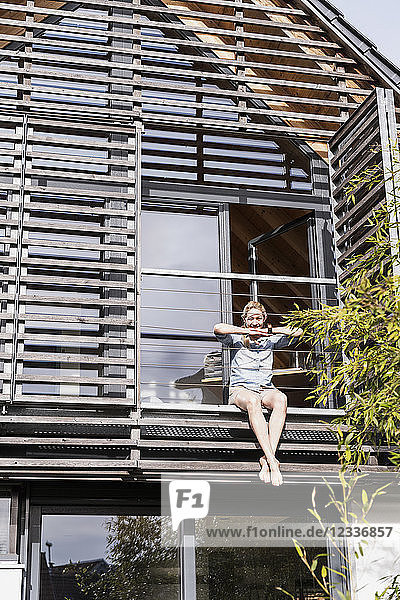 Woman relaxing on balcony of her house