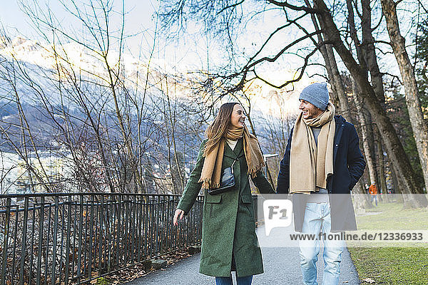 Austria  Innsbruck  happy young couple strolling together hand in hand at winter time