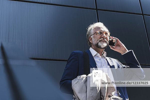 Mature businessman on cell phone outdoors