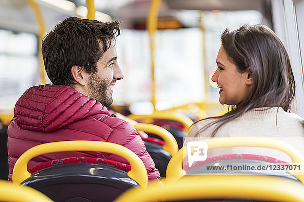 UK  London  happy young couple sitting side by side in bus