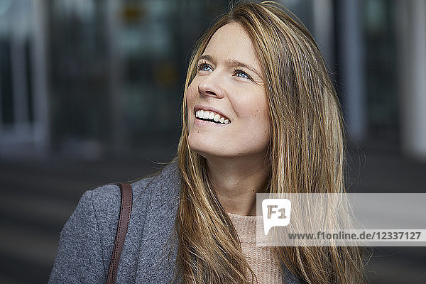 Portrait of smiling businesswoman watching something